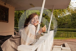 Pretty lady outdoor. Happy woman holding flower and smiling outdoors