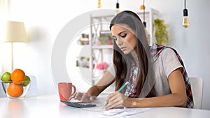 Pretty lady planning home budget, counting incomes and expenses, saving money photo