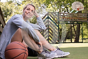 pretty lady sitting on basketball court