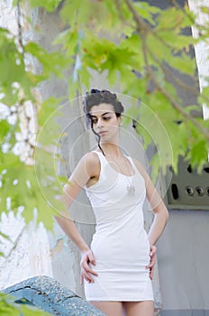 Pretty lady standing front old house wearing a tight short white dress