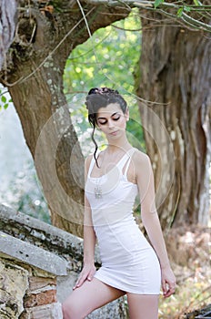 Pretty lady standing front old house wearing a tight short white dress