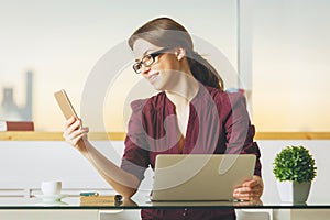 Pretty lady using smartphone and laptop