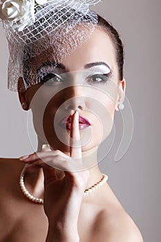 Pretty lady in white hat with veil and roses, retro glamour beauty portrait. Beautiful woman with perfect makeup