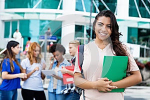 Pretty latin american female student with group of other international students photo