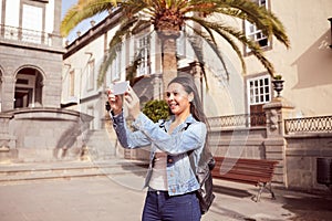 Pretty laughing girl taking pictures on cell phone