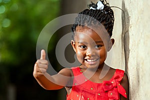 Pretty little african girl showing thumbs up. photo