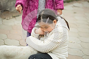 Pretty little asian girl palying with dog