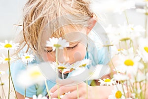 Pretty Little Blond Girl Smelling Daisies