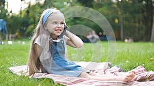 Pretty little child girl having conversation on her mobile phone in summer park