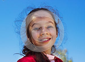 Pretty little girl against blue summer sky background