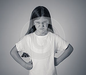 Pretty little girl with a angry facial expression looking mad at the camera. Children emotions