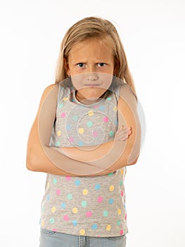 Pretty little girl with a angry facial expression looking mad at the camera. Human emotions