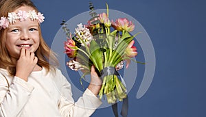 Pretty little girl with bouquet of spring tulips flowers for woman or mothers day 8 march happy smiling