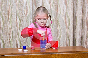 Pretty little girl doing physical water experiments at home