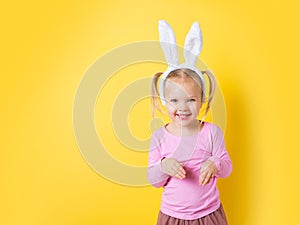 Pretty little girl easter bunny on yellow background