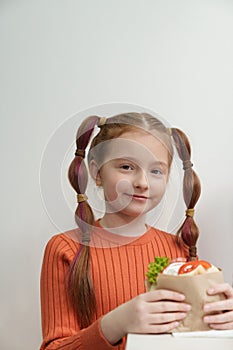 Pretty little girl eats souvlaki and pita bread in traditional Greek restaurant. Portrait of cute white kid enjoing lunch meal in