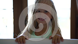 Pretty little girl frightens for fun jumping out of hiding