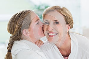 Pretty little girl kissing her mother on cheek