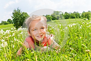 Pretty little girl laying on the grass