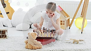 Pretty little girl playing chess