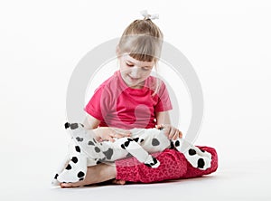 Pretty little girl playing with plush dog
