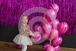 Pretty little girl plays with pink balloons