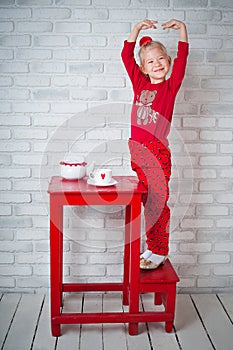 Pretty little girl posing near table