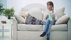 Pretty little girl reading fairy-tale for her teddy-bear, kissing it, saing good-night.