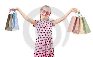 Pretty little girl with shopping bag, studio portrait, dressed in pink with heart shapes, white background