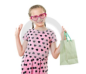 Pretty little girl with shopping bag, studio portrait, dressed in pink with heart shapes, white background