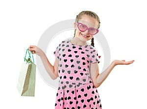 Pretty little girl with shopping bag, studio portrait, dressed in pink with heart shapes, white background