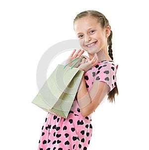 Pretty little girl with shopping bag, studio portrait, dressed in pink with heart shapes, white background