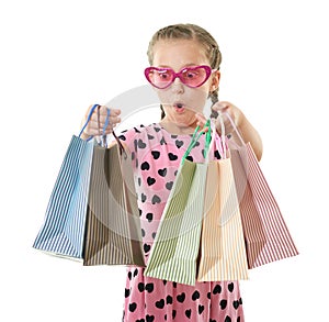 Pretty little girl with shopping bag, studio portrait, dressed in pink with heart shapes, white background