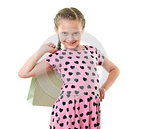 Pretty little girl with shopping bag, studio portrait, dressed in pink with heart shapes, white background