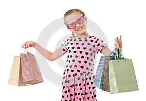 Pretty little girl with shopping bag, studio portrait, dressed in pink with heart shapes, white background