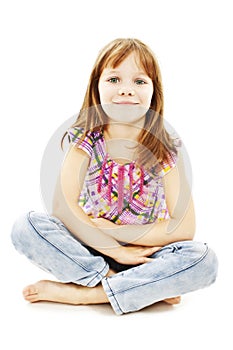 Pretty little girl sitting on the floor in jeans