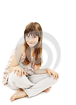 Pretty little girl sitting on the floor in jeans