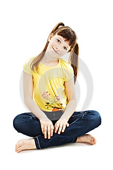 Pretty little girl sitting on the floor in jeans