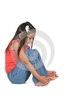 Pretty little girl studying her bare toes