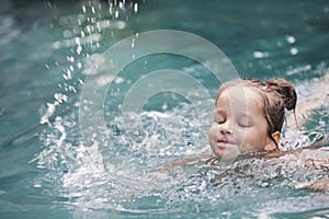 Pretty little girl in swimming pool