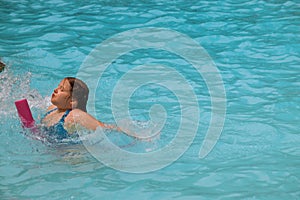 Pretty little girl in swimming pool in sunny day