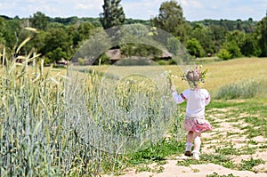 Pretty little girl walking away on rural road