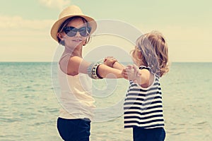 Pretty little girls (sisters) dancing on the beach.