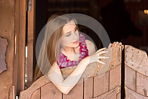 Pretty long hair Cowgirl standing in saloon entrance