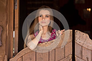 Pretty long hair Cowgirl standing in saloon entrance