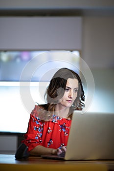 Pretty, mid-aged woman using her laptop at home