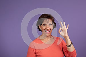 Pretty middle Age woman giving Okay sign