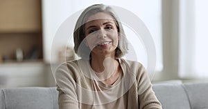 Pretty middle aged grey haired woman posing at home