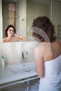 Pretty, middle aged woman brushing her teeth