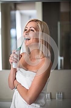 Pretty, middle aged woman brushing her teeth